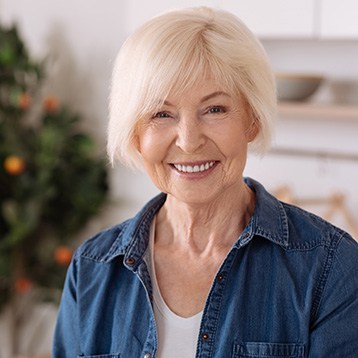 A cheerful elderly woman standing in the kitchen