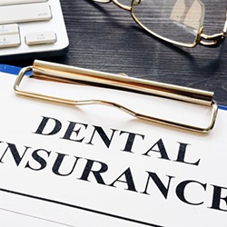 a dental insurance form next to a keyboard